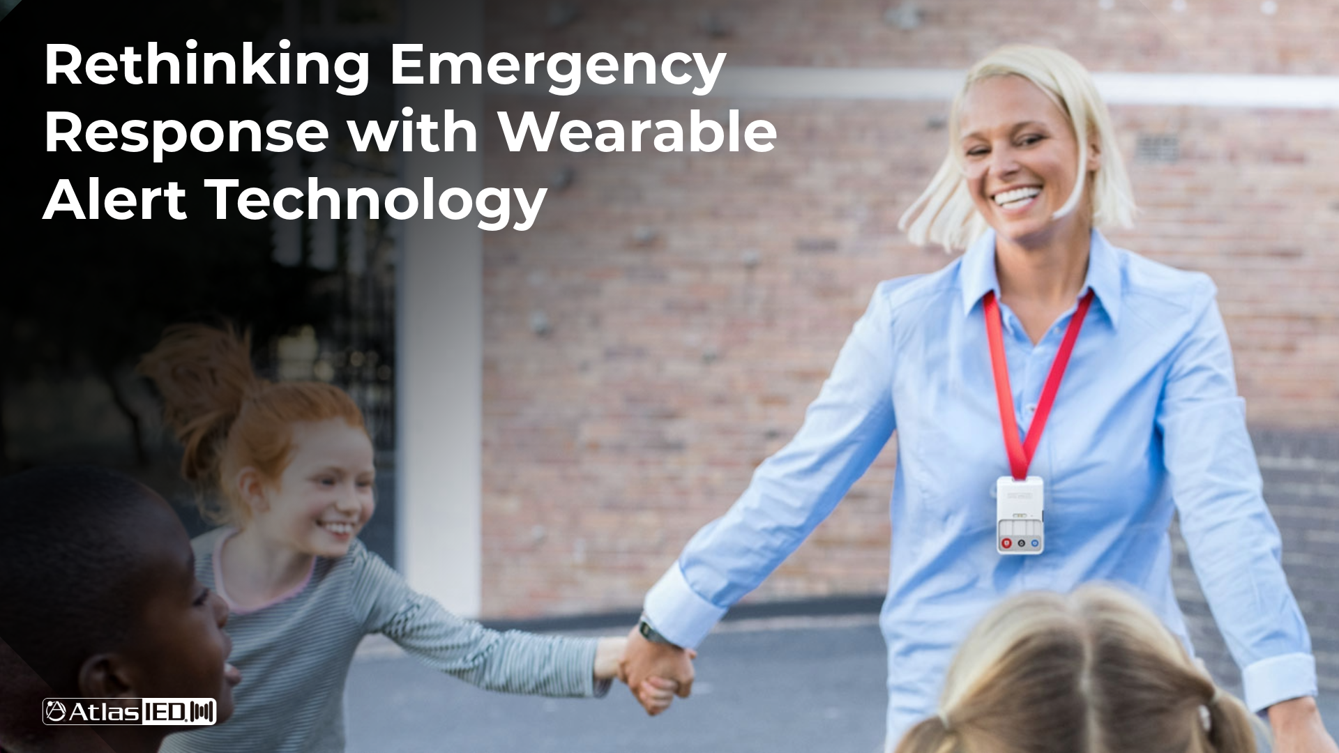 teacher playing with students outside at recess while wearing AtlasIED Rapid Alert security device